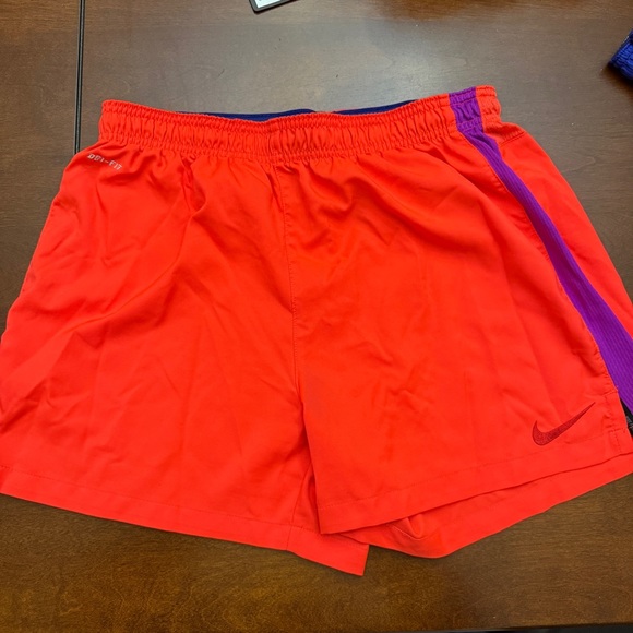 Nike Orange Shorts with purple side stripe accent. - Picture 1 of 3